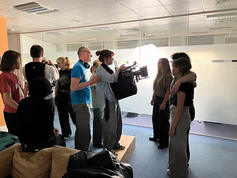 Jenny uses an apple box to attain the required height